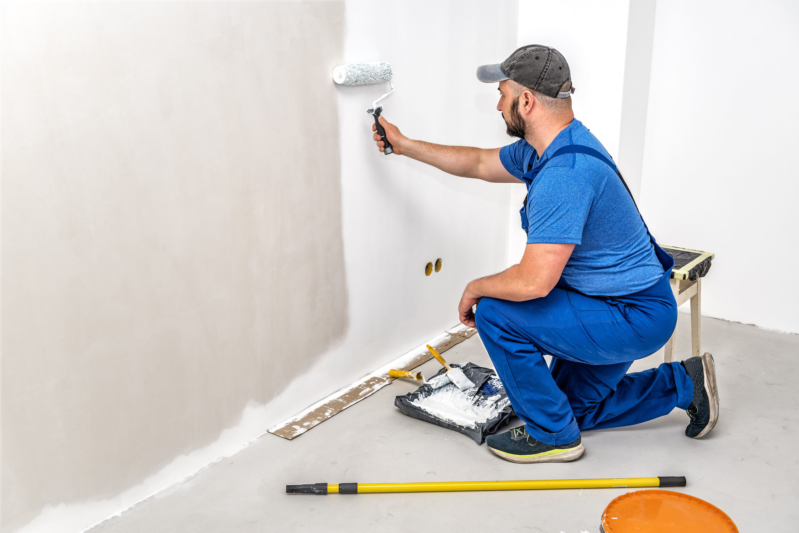 Image of a worker painting a white wall